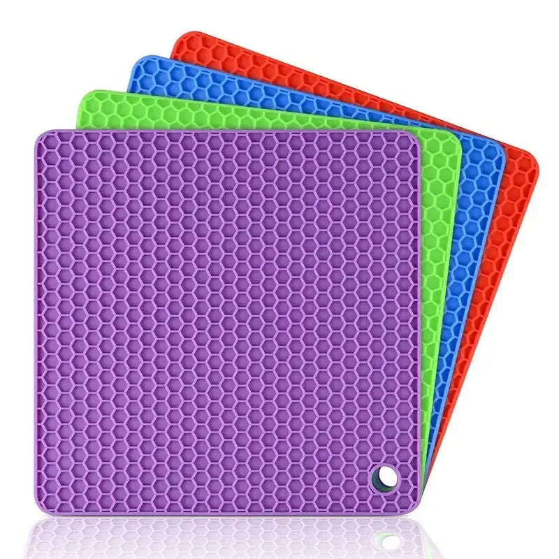 Four colorful silicone mats with honeycomb pattern on a white background