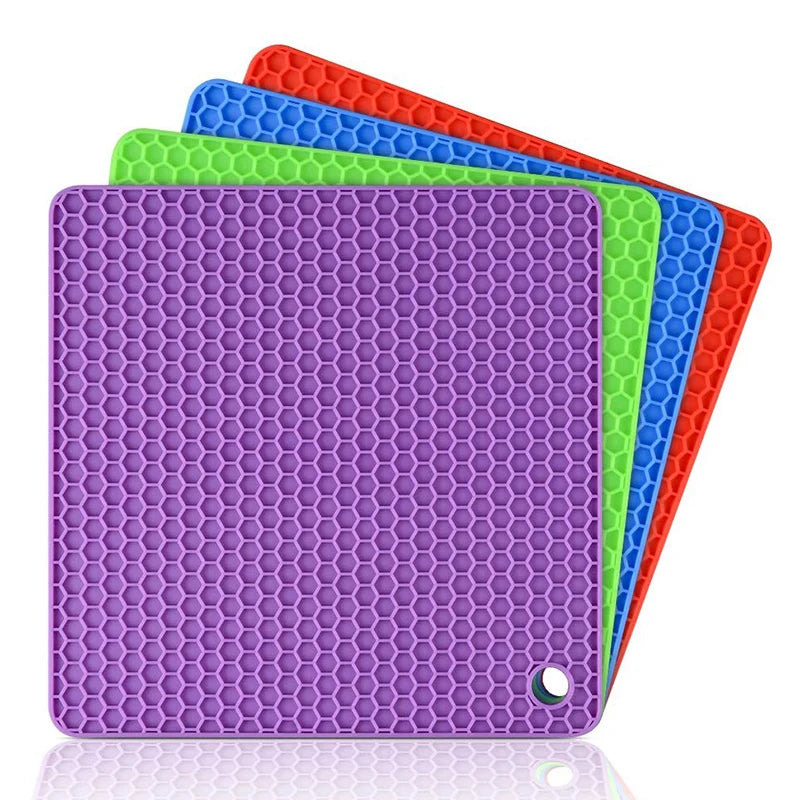 Four colorful silicone mats with honeycomb pattern on a white background