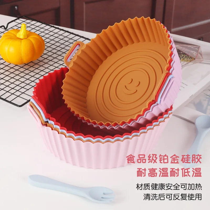 Set of silicone baking cups in red, orange, and pink on a kitchen counter.