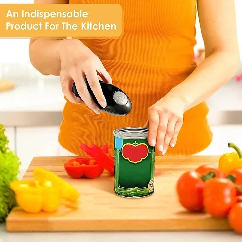A person in an orange top uses a black electric can opener to open a green can with a red tomato graphic label, set on a wooden cutting board with fresh vegetables in a bright kitchen.