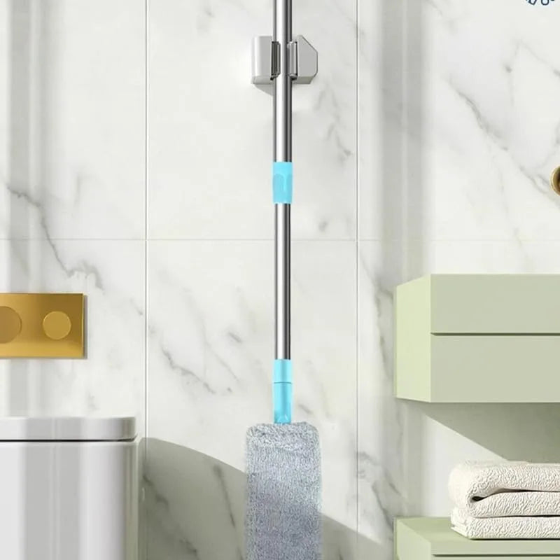 Mop with a blue cleaning tool attached to a marble wall in a bathroom setting.