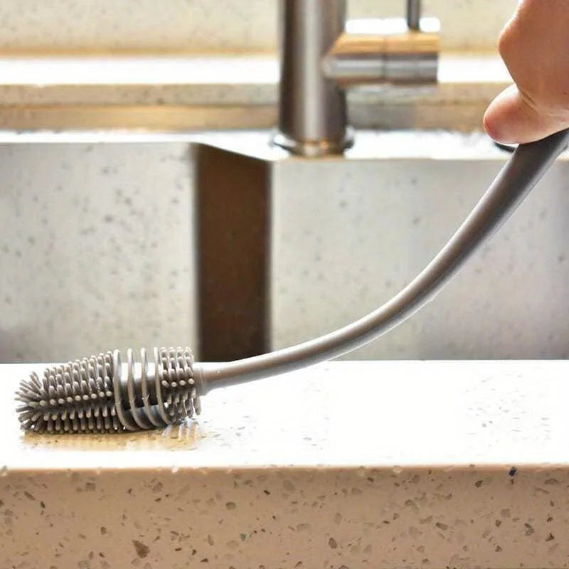 Kitchen brush with bristle head on a countertop next to a faucet