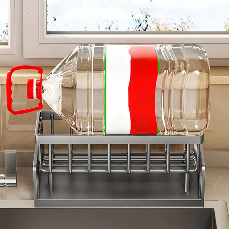 Dish rack with glasses and a bottle on a kitchen counter, with a window in the background.