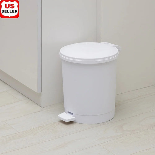 White trash bin with foot pedal on a light wooden floor.