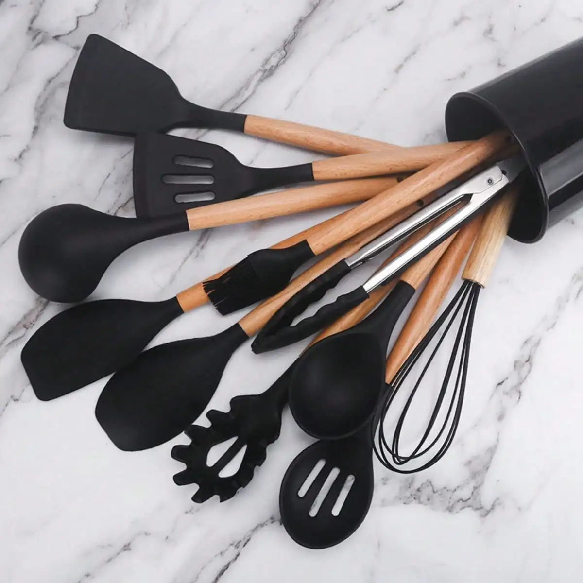 Set of black and wooden kitchen utensils on a marble surface