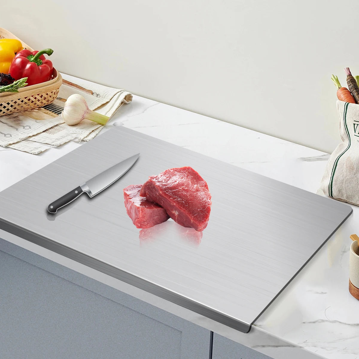 Butcher block with raw meat, knife, and vegetables on a kitchen counter