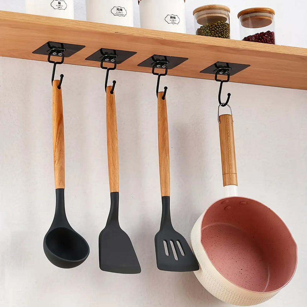 Set of kitchen utensils with wooden handles hanging on a wooden shelf.