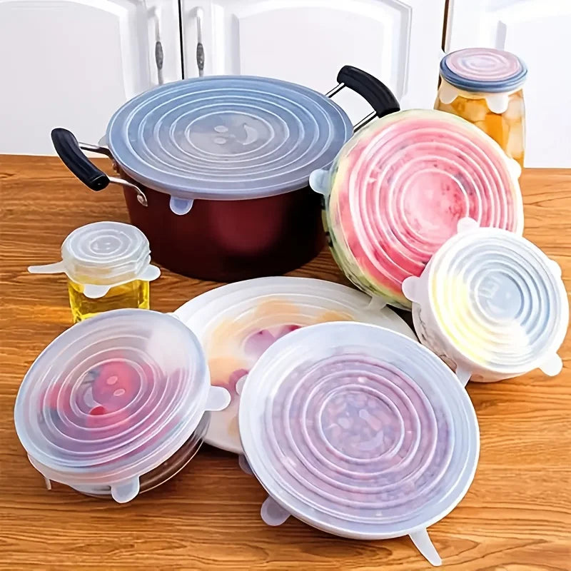 Silicone stretch lids on various containers on a wooden surface