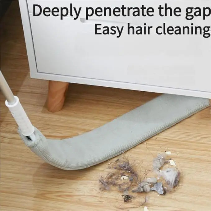 Cleaning tool being used to clean gaps under a piece of furniture with collected hair and debris.