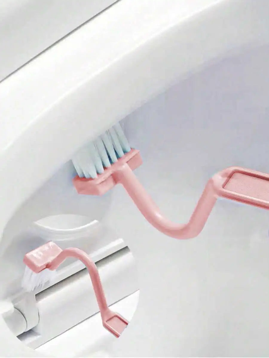 Pink toilet cleaning brush with dual bristles, shown inside a white toilet bowl with an inset detail of the hinge-mounted brush.