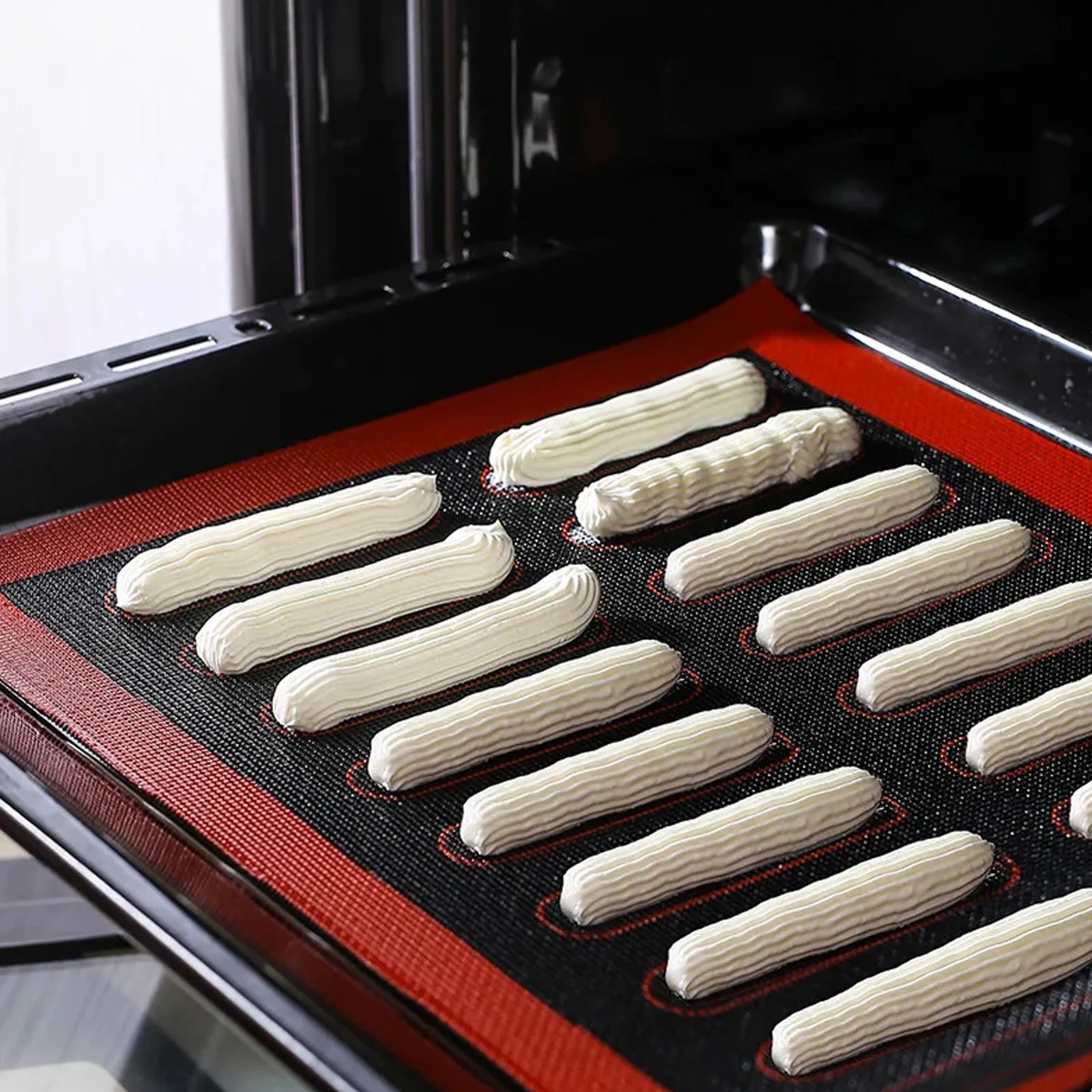Baked goods on a baking tray with a silicone mat inside an oven.