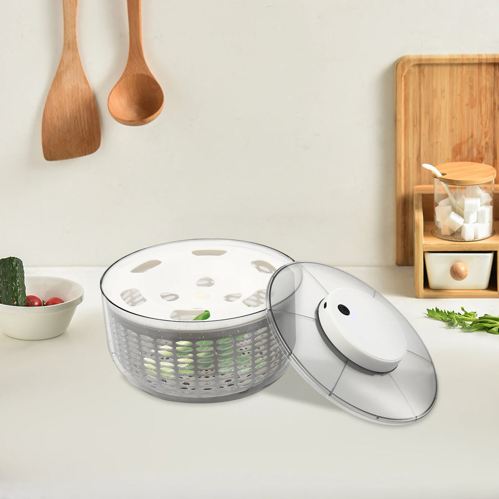 Salad spinner on a kitchen counter with wooden utensils and a cutting board in the background.