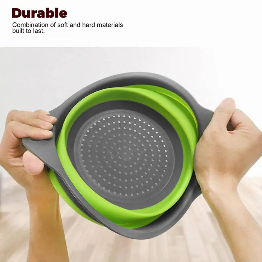Collapsible colander with green interior and gray exterior held by hands against a white background.
